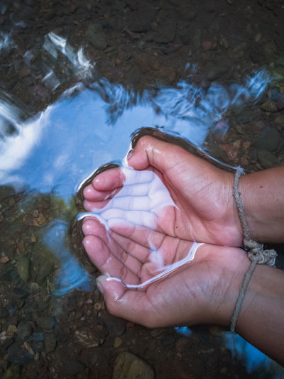 Cropped image of person dipping hands in water