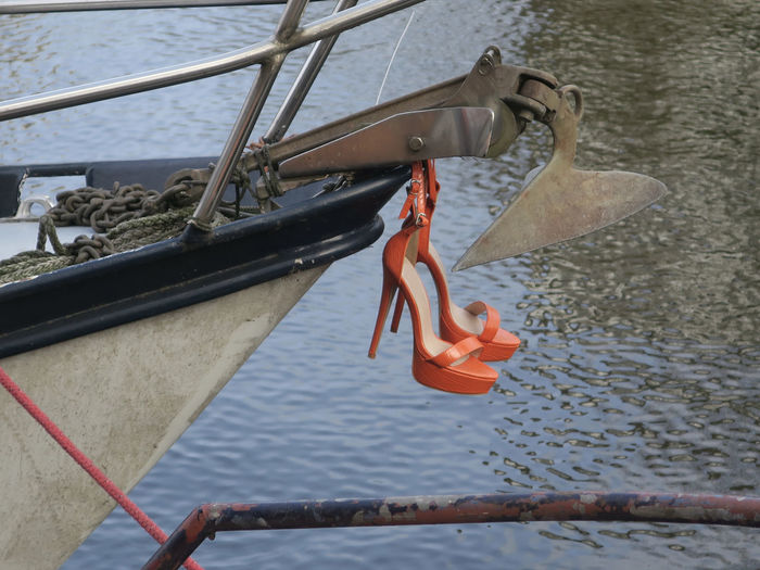Close-up of rope hanging on railing by river