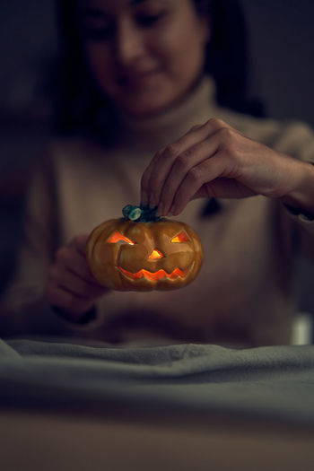Midsection of woman holding jack o lantern