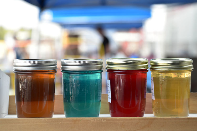 Row of glass jars of colorful artisanal jelly at farmer's  market 