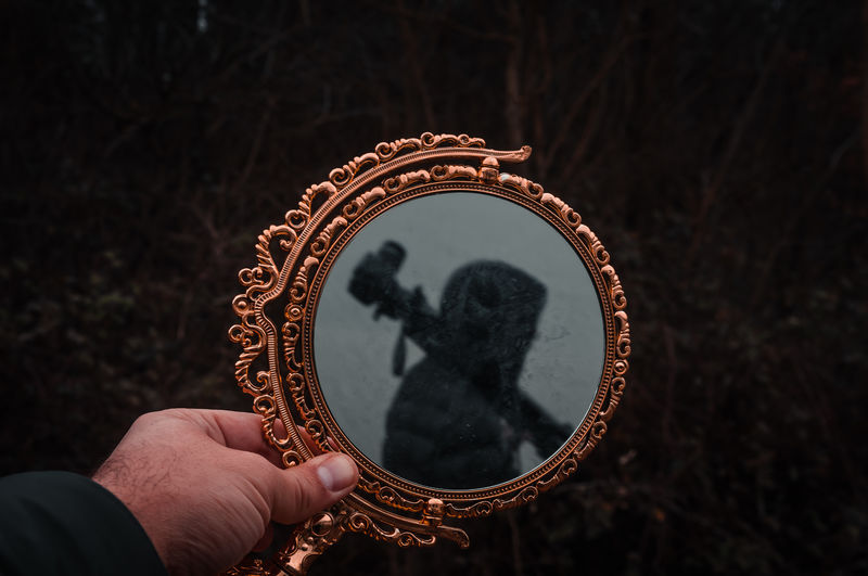 Closeup view of mirror reflection and human hand