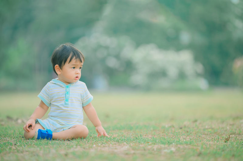 Cute boy looking away on field