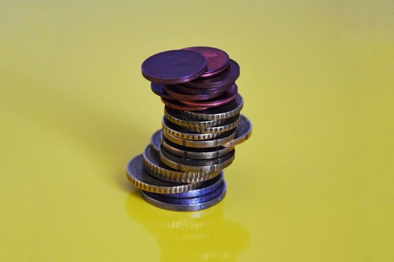Close-up of coins stack against yellow background