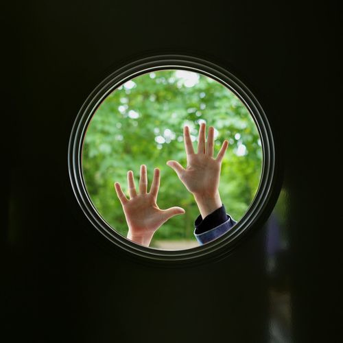 Silhouette hands touching round window