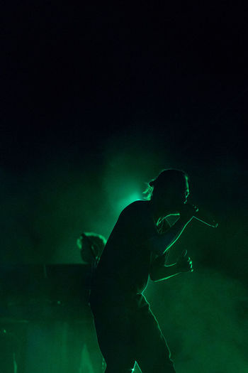 Rear view of man at music concert at night