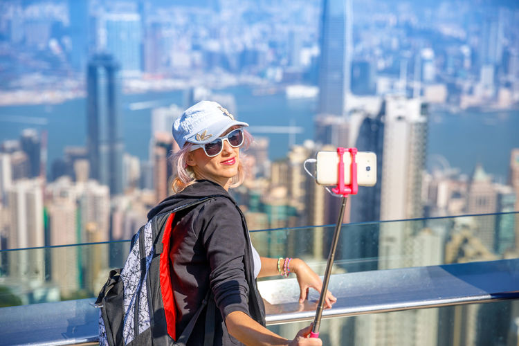 High angle view of woman taking selfie with mobile phone against cityscape