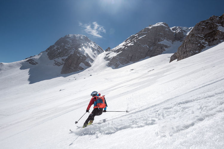 Person skiing on snowcapped mountain against sky