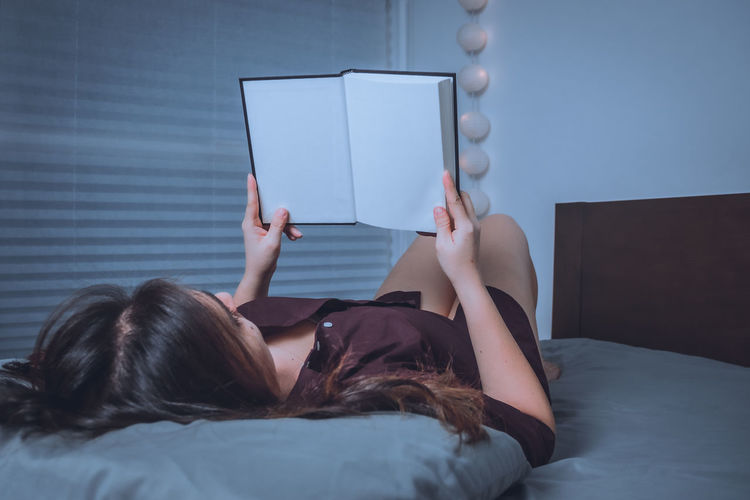 Woman lying on bed at home