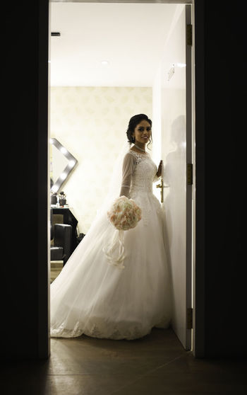 Portrait of bride standing on doorway
