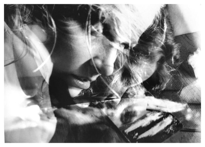 Double exposure image of thoughtful woman looking away by cocaine on coffee table