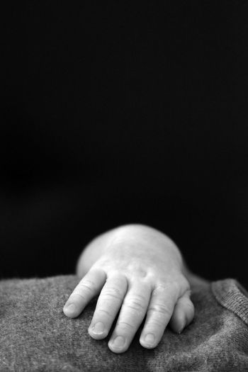 Close-up of baby hand against black background