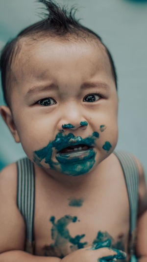 Portrait of cute baby boy with paint on face