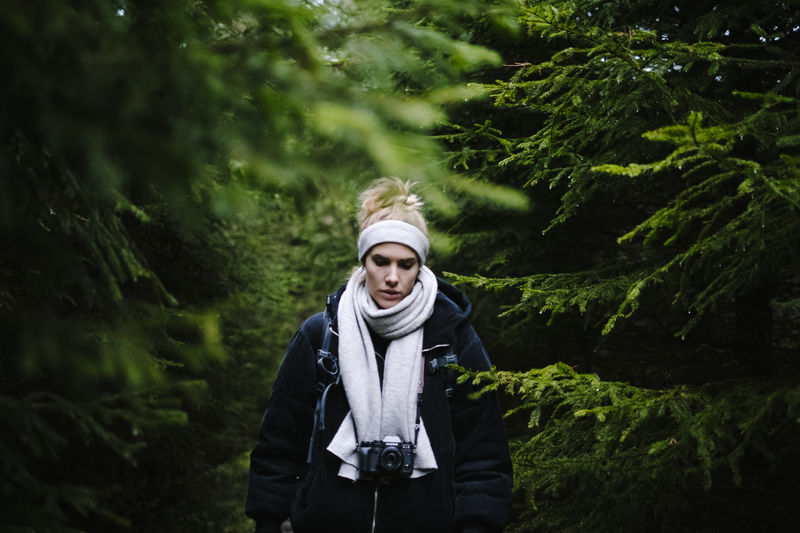 Woman standing amidst trees in forest