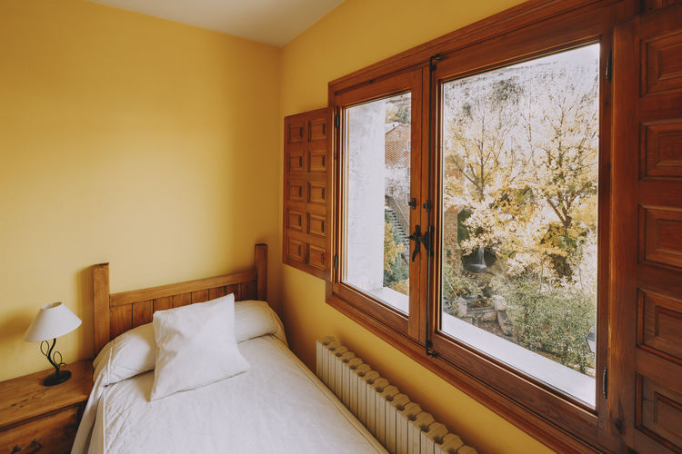 Top view of a wooden bed in a rural hotel single room.