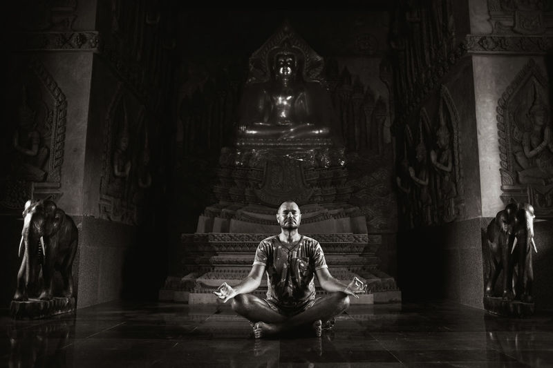 Full length of man doing yoga in buddhist temple