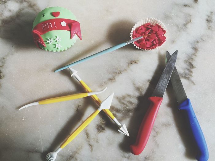 High angle view of cupcake with kitchen knives on table