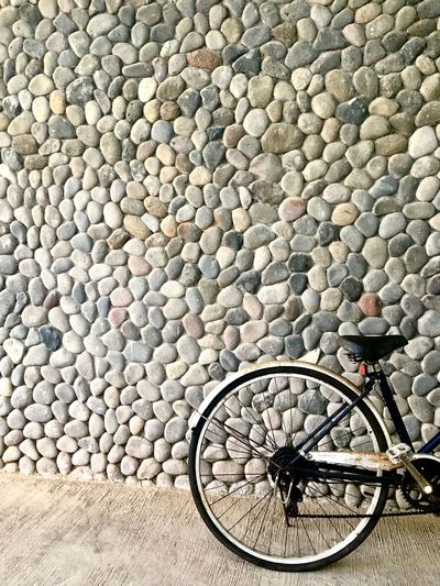 High angle view of bicycle parked by stone wall