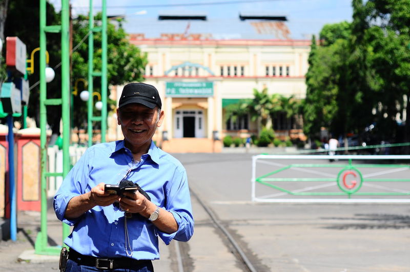 Portrait of senior man using mobile phone on road