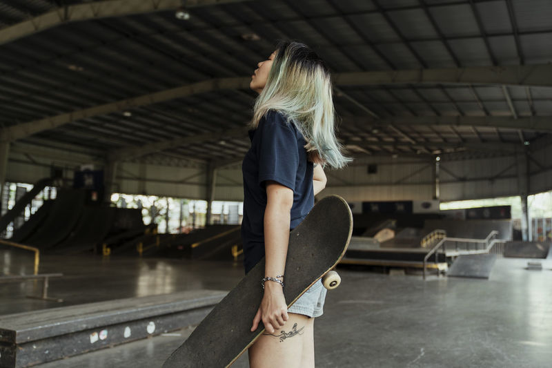 Side view of woman with skateboard