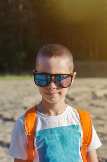 Summer portrait of a child wearing glasses with short hair outdoors