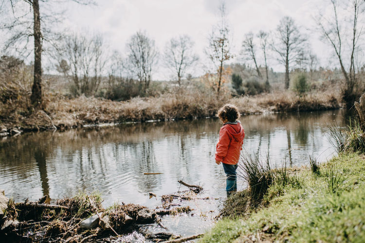 Full length of girl standing by pond