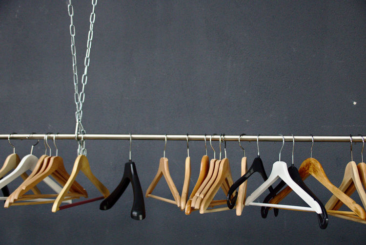 Close-up of clothes hanging on metal against wall
