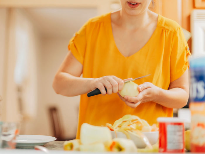 Young millennial mother at home in the kitchen preparing ingredients for apple crisp