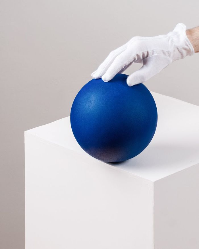 CLOSE-UP OF BLUE BALL ON TABLE AGAINST WHITE BACKGROUND
