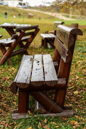 Close-up of old wooden bench on field