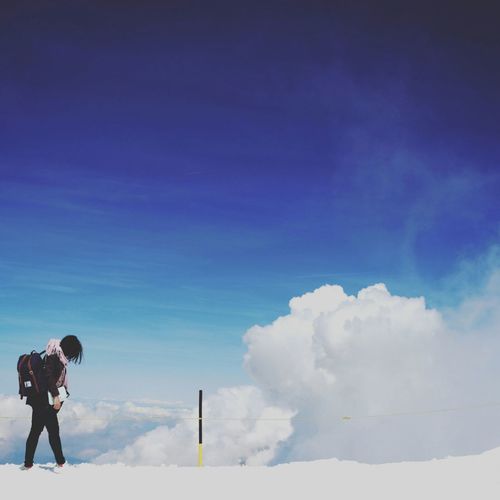 Woman on snow covered landscape against sky