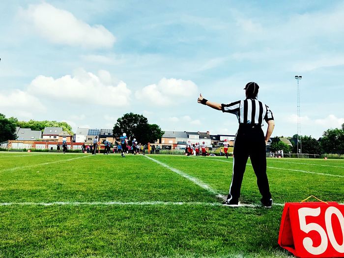 Rear view of referee showing thumbs up on soccer field