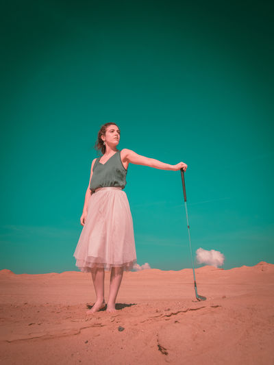 Full length of young woman standing on sand