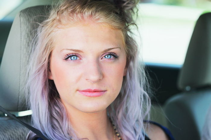 Close-up portrait of confident young woman sitting in car