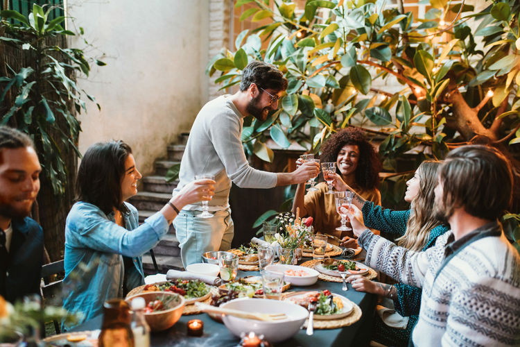 High angle view happy friends toasting drink during party
