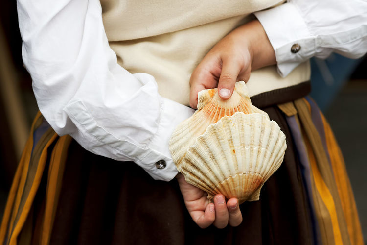 Midsection of woman holding large seashells