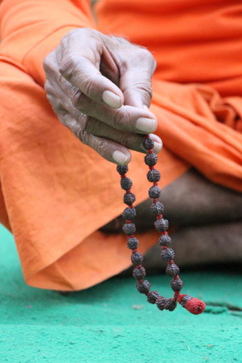 Close-up of man holding prayer beads
