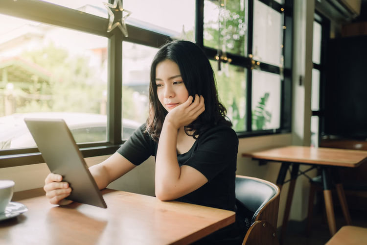 Portrait of woman sitting on chair in cafe