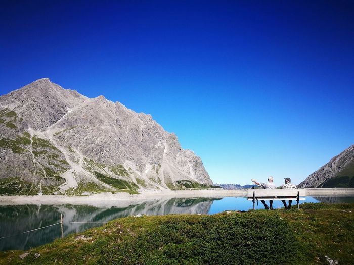 Scenic view of lake against clear blue sky