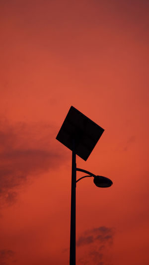 Low angle view of street light against orange sky