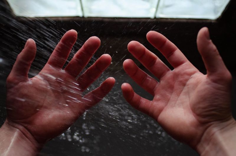 Close-up of hands on wet floor