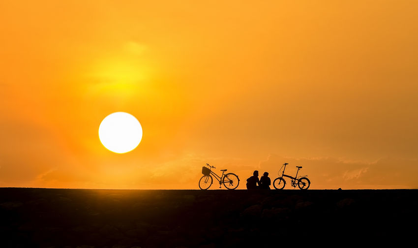 Silhouette bicycle against sky during sunset