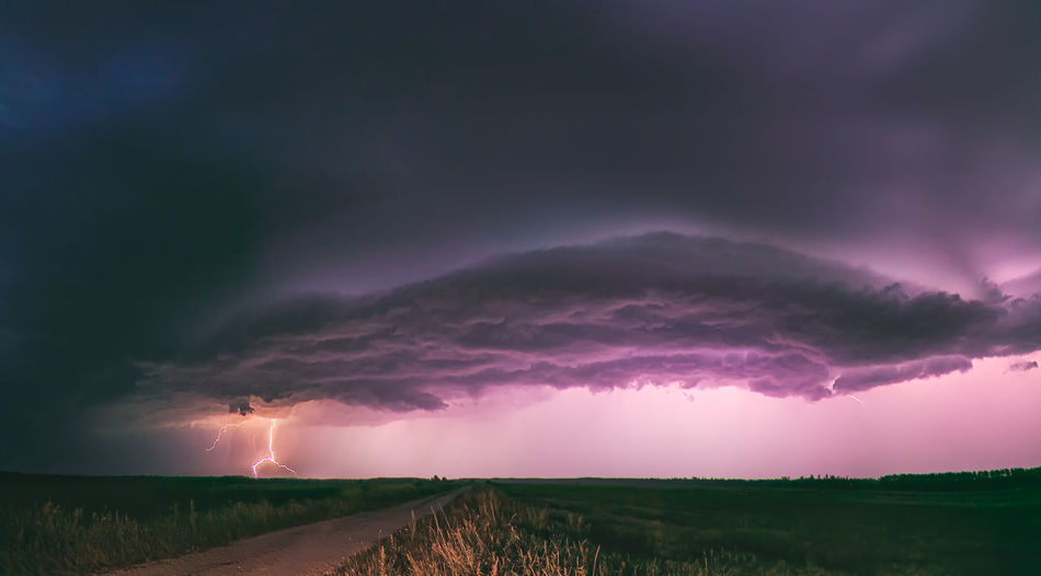 Scenic view of storm clouds over field