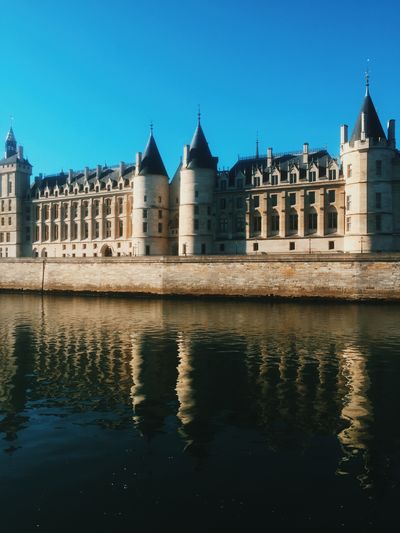 Historic building by seine river against clear blue sky