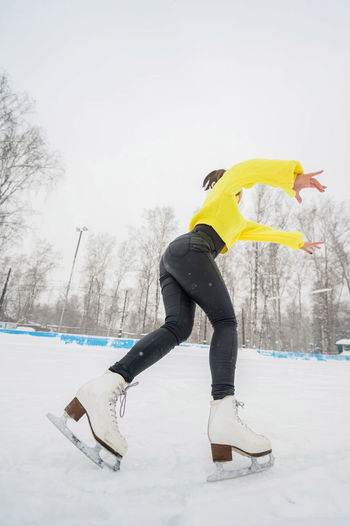 Full length of woman ice skating on snow covered land