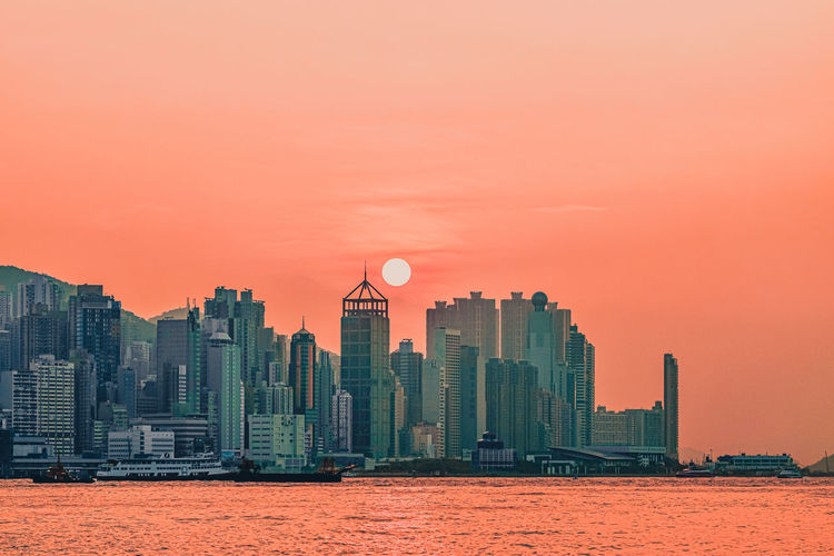 Buildings in city against sky during sunset