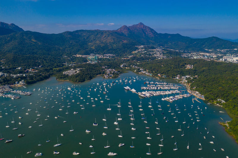 Aerial view of boats moored in sea by townscape