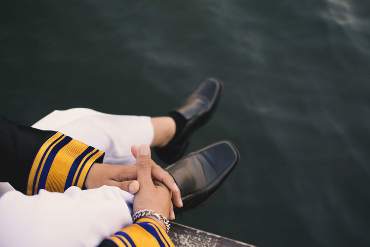 Close-up of man sitting by water