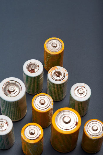 Close-up of battery in container against colored background