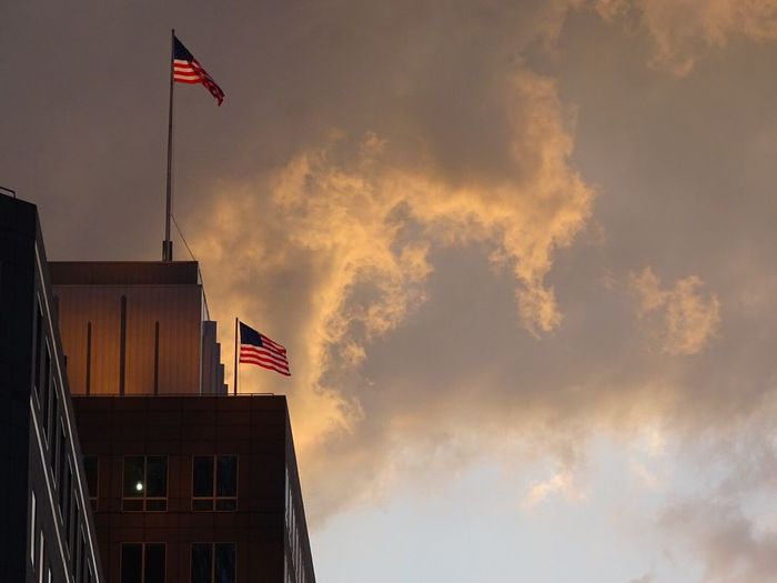 Low angle view of flag against cloudy sky