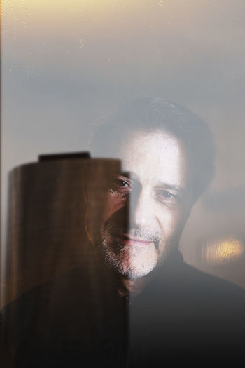 Portrait of man by glass window